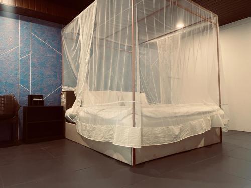 a canopy bed with white curtains in a room at Patnem Garden Resort in Patnem