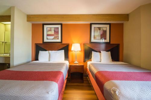 two beds in a hotel room with two lamps at Motel 6-Indianapolis, IN - Airport in Indianapolis