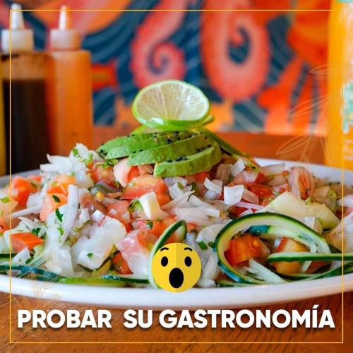 a plate of food with a salad with a lime at La placita hotel in Río Lagartos