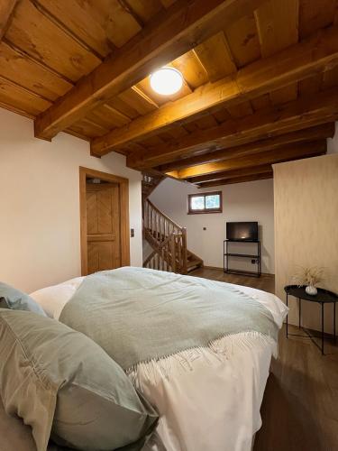 a bedroom with a bed and a wooden ceiling at Apartmán La Šiška - Věžička in Velké Karlovice
