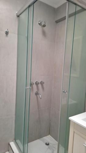 a shower with a glass door in a bathroom at Apartamentos del campus in Manzone