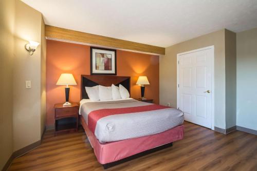 a hotel room with a bed and two lamps at Motel 6-Indianapolis, IN - Airport in Indianapolis