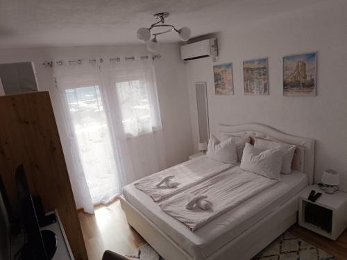 a bedroom with a white bed with two towels on it at SWEET APT Zenica in Zenica