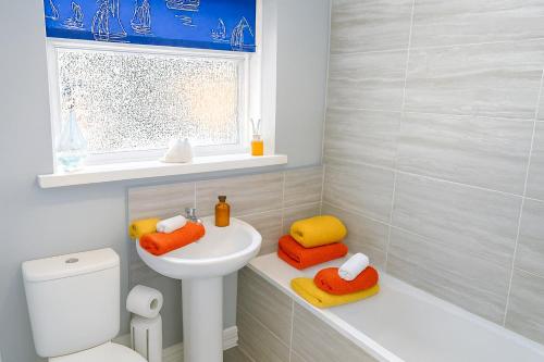 a bathroom with a sink and a toilet and a window at A Bolt Hole by the beach in Northumberland in Newbiggin-by-the-Sea