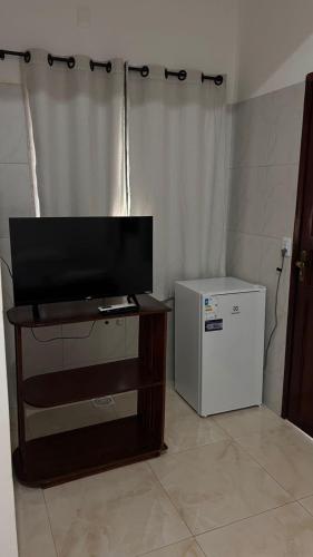 a living room with a television and a refrigerator at CAMA & CAFÉ BED & BREAKFAST HOSPEDARIA MORRO BRANCO 3 MIN A PÉ DAS FALÉSIAs 2 QUADRAS DA PRAIA 1 QUADRA DO MIRANTE & FEIRINHA in Beberibe