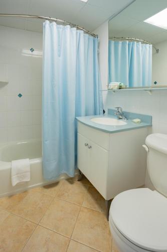 a bathroom with a toilet and a sink and a shower at Concord Suites in Avalon