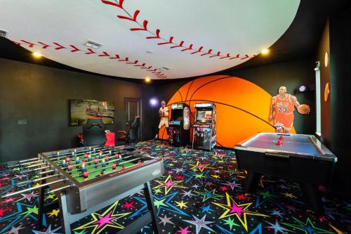 a room with a foosball table and a pool table at Amazing 8br w pool theater game room by Disney in Kissimmee