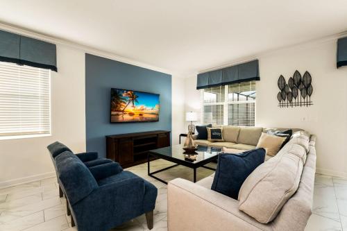 a living room with a couch and a table at Amazing 8br w pool theater game room by Disney in Kissimmee