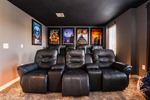 a living room with a leather reclining couch at Amazing 8br w pool theater game room by Disney in Kissimmee