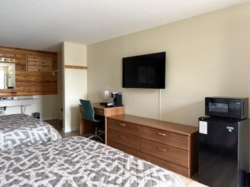 a bedroom with a bed and a desk and a television at The Trail Inn - Grantsburg, WI - 703 WI-70 in Grantsburg