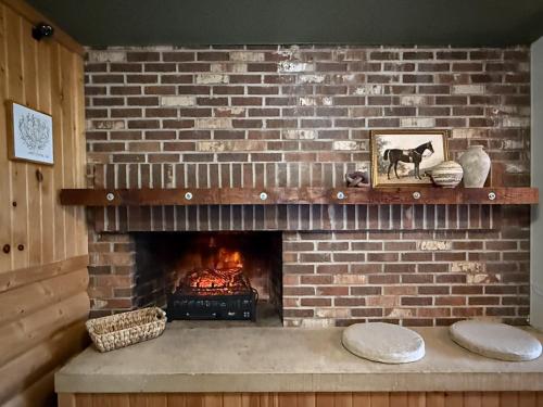 a brick fireplace with a fire in it at The Trail Inn - Grantsburg, WI - 703 WI-70 in Grantsburg