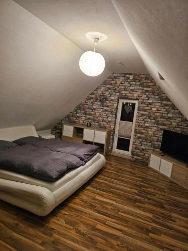 a bedroom with a bed and a brick wall at Haus Margot in Katharinenberg