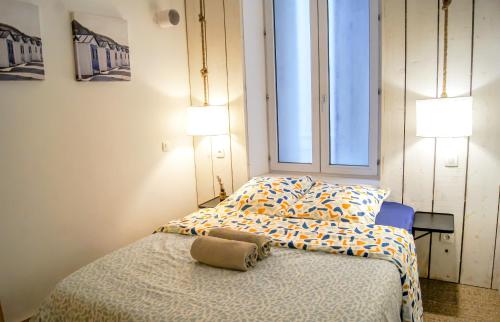 a bedroom with a bed and two lamps and a window at Le Havre Familial - 5 couchages climatisé in Romans-sur-Isère