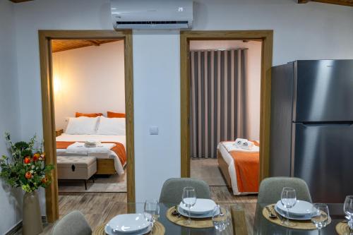 a room with a table and chairs and a bedroom at Casa Da Eira Caramulo in Varzielas