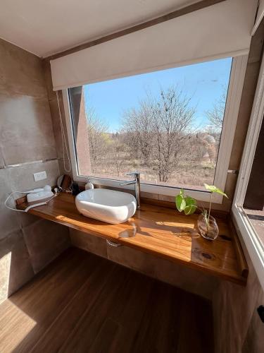 a bathroom with a sink and a large window at DelViento Cabañas in Las Rabonas