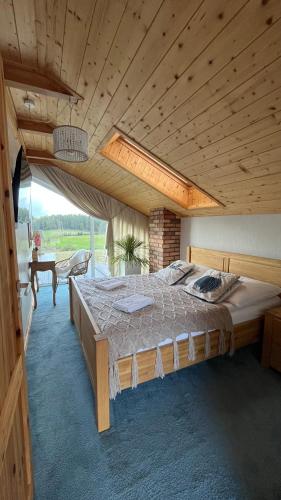 a large bed in a room with a wooden ceiling at Czaple Resort in Stare Czaple