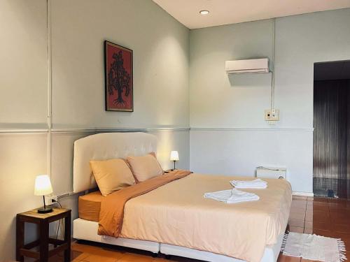 a bedroom with a bed and a picture on the wall at Thakhek Travel Lodge in Thakhek