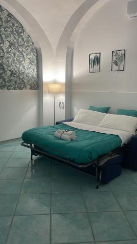 a bed in a room with a green mattress at Porta della costiera in Vietri sul Mare