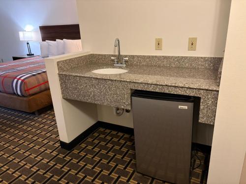 a hotel room with a sink and a bed at Regency Inn & Suites in Milton