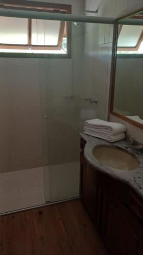a bathroom with a shower and a sink and a mirror at Hotel San Carlos in Carlos Barbosa