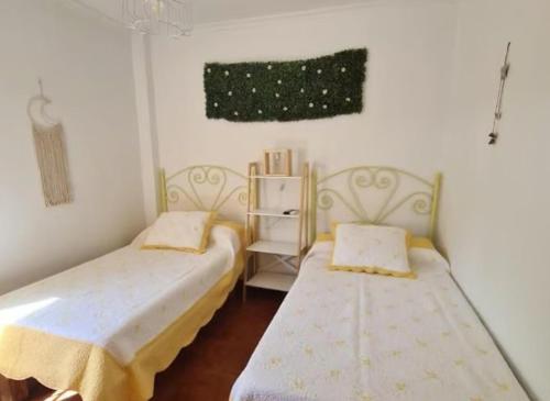 a room with two beds and a shelf at Casa Rural Kentia in Valdepeñas