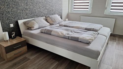 a bedroom with a white bed with a night stand at Pension Bernburg A2 in Bernburg