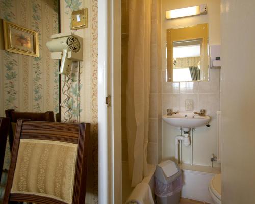 a small bathroom with a sink and a mirror at Moonraker House in Stratford-upon-Avon