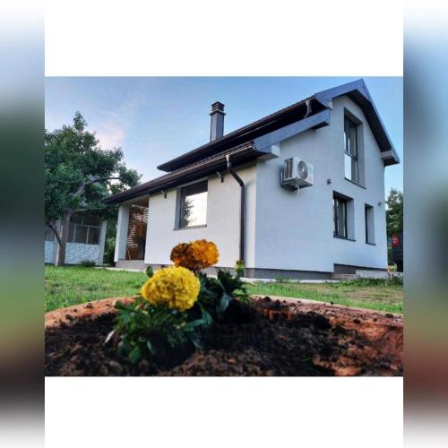 a white house with flowers in the front yard at House For Rest VIN in Kolašin