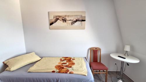a bedroom with a bed and a picture on the wall at Pension Bernburg A² in Bernburg