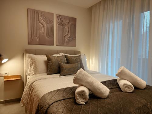 a bedroom with a large bed with towels on it at AuRa The Golden Suite in Alexandroupoli