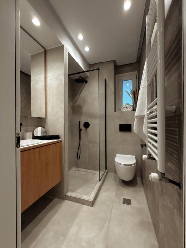 a bathroom with a shower and a toilet and a sink at AuRa The Golden Suite in Alexandroupoli