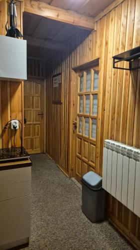 a hallway of a kitchen with wood paneled walls at Limba in Ząb