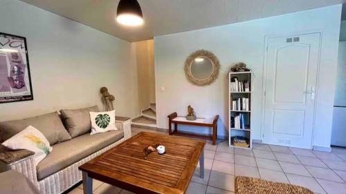 a living room with a couch and a coffee table at MOOREA - Waterfall Pool Coconut House 1 in Pihaena