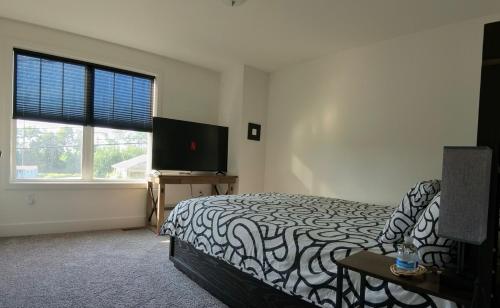 a bedroom with a bed and a flat screen tv at Perfect Family Getaway! Steps from Attractions in Hummelstown