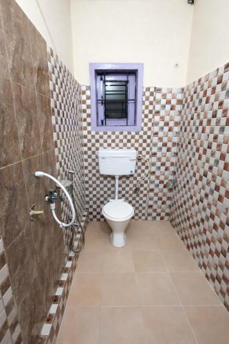 a bathroom with a toilet and a window at Whitestone Inn in Guwahati