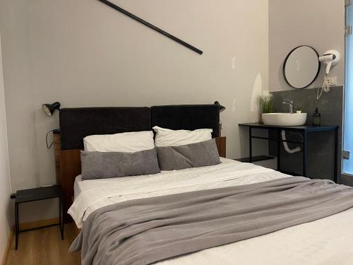 a bedroom with a large bed with a black headboard at E - Central Room Five in Skopje