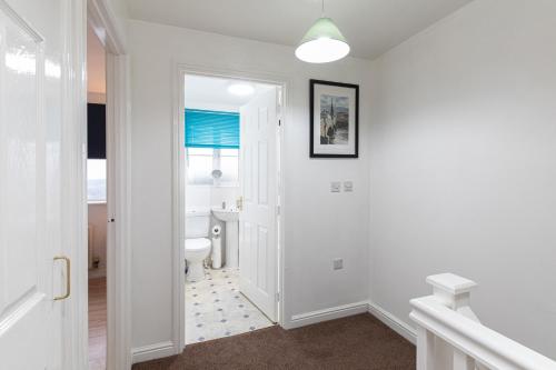 a white bathroom with a toilet and a window at Valley View in Shield Row