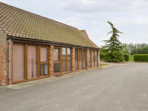 a brick building with windows next to a street at Koi Keep - Ukc1909 in Doddington