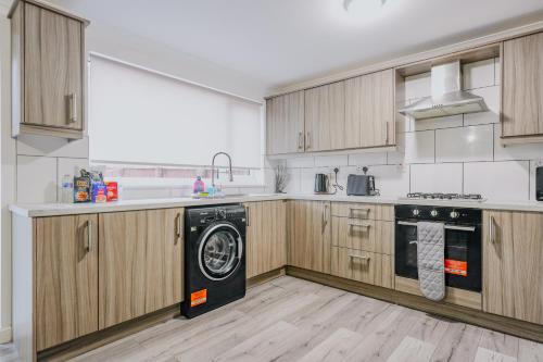 a kitchen with wooden cabinets and a black dishwasher at Dunward House in Livingston