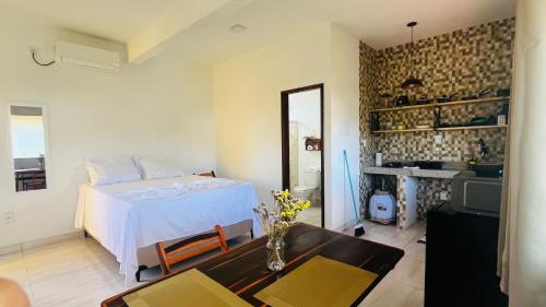 a bedroom with a bed and a table and a television at Quitinetes espaçosos com ar para um casal na Ilha de Boipeba in Ilha de Boipeba