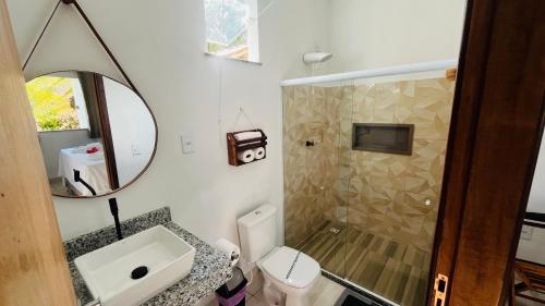 a bathroom with a toilet and a sink and a shower at Quitinetes espaçosos com ar para um casal na Ilha de Boipeba in Ilha de Boipeba