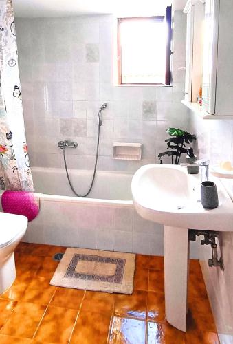 a bathroom with a sink and a shower and a tub at Sea view house II in Dhílesi