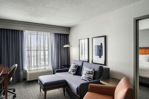 a hotel room with a couch and a bed at Courtyard Hamilton in Hamilton