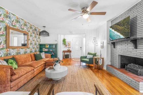 a living room with a couch and a fireplace at Raleigh's Most Wanted - Relax, Games, & Cozy Comfort in Raleigh