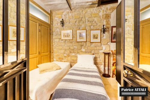 a bed in a room with a stone wall at Marais Romantique Paris centre 4 chambres in Paris