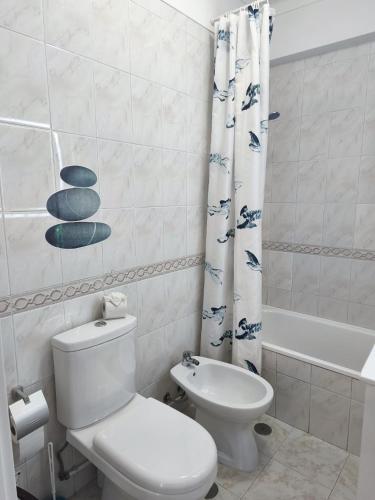 a bathroom with a toilet and a shower curtain at Blue Apartment in Portimão