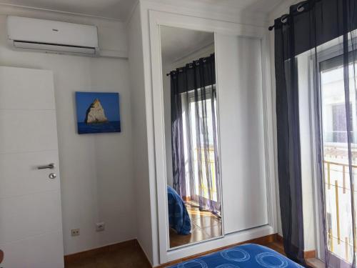 a large mirror in a room with a window at Blue Apartment in Portimão