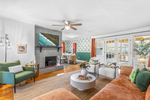 a living room with a couch and a fireplace at Raleigh's Most Wanted - Relax, Games, & Cozy Comfort in Raleigh