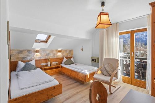 a room with a bed and a couch and a chair at Gästehaus Florian in Grainau