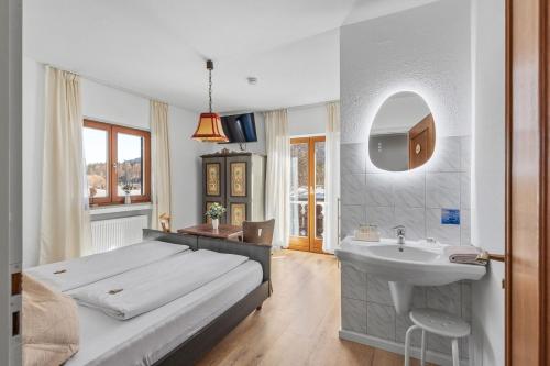 a bedroom with a bed and a sink and a mirror at Gästehaus Florian in Grainau